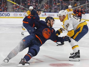 Nashville Predators defenceman Mark Borowiecki trips up Edmonton Oilers forward Connor McDavid (97) at Rogers Place on Thursday, Jan. 27, 2022.