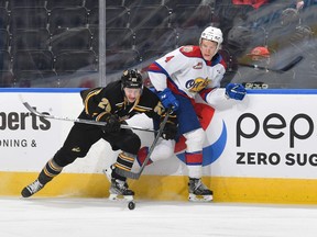 Edmonton Oil Kings defenceman Kaiden Guhle (No. 4), battles for the puck against Tyson Zimmer (No. 25) of the Brandon Wheat Kings at Rogers Place on Jan. 15, 2022.
