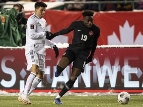 Canada's Alphonso Davies (19) and Mexico's Julio Cesar Domingguez Juarez (3) vie for the ball during World Cup qualifiers at Commonwealth Stadium in Edmonton on Nov. 16, 2021.