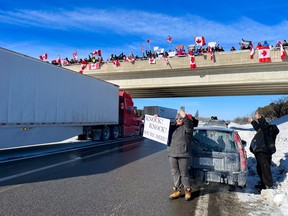 Supporters of truckers protesting the Canadian government’s vaccine mandate for cross-border truckers gathered on the Dilworth Rd. highway 416 overpass, south of Ottawa, as the convoy made its way to the nation's capital on Friday, Jan. 28, 2022.