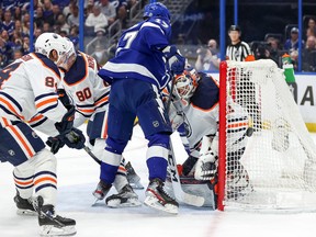 Mike Smith (41) of the Edmonton Oilers makes a save against Alex Killorn (17) of the Tampa Bay Lightning as he's defended by William Lagesson (84) and Markus Niemelainen (80) at the Amalie Arena on Wednesday, Feb. 23, 2022, in Tampa, Fla.