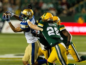 Edmonton Elks safety Jordan Hoover (28) reaches for Winnipeg Blue Bombers receiver Kenny Lawler (89) as he catches the ball at Commonwealth Stadium in Edmonton on Oct. 15, 2021.