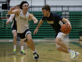 Brandon Meiklejohn, left, and Colton Gibb take part in a University of Alberta Golden Bears practice at the Saville Community Sports Centre in Edmonton on Thursday, Feb. 24, 2022.