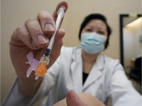 A pharmacist administers a COVID-19 vaccine.