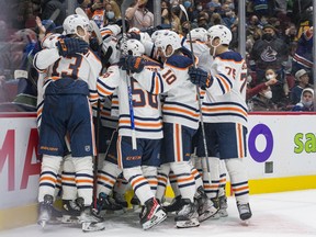 The Edmonton Oilers celebrate their 3-2 overtime victory against the Vancouver Canucks at Rogers Arena on Jan. 25, 2022.