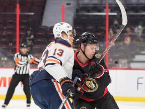 Edmonton Oilers right wing Jesse Puljujarvi (13) battles against Ottawa Senators left wing Brady Tkachuk (7) at Canadian Tire Centre on Monday, Jan. 31, 2022.