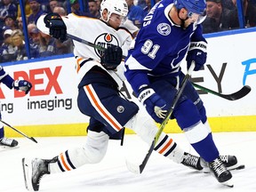 Edmonton Oilers defenceman Markus Niemelainen (80) and Tampa Bay Lightning centre Steven Stamkos (91) fight to control the puck at Amalie Arena on Wednesday, Feb. 23, 2022.