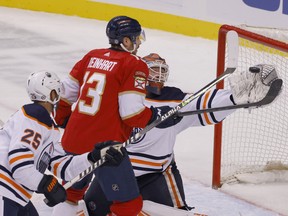 Edmonton Oilers goaltender Mikko Koskinen (19) makes a save as Florida Panthers center Sam Reinhart (13) and Oilers defenceman Darnell Nurse (25) close in at FLA Live Arena.