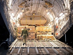 This handout picture released by the press service of the General Staff of the Ukrainian Armed Forces shows workers unloading a military transport aircraft C-17 of the Royal Canadian Air Force with Canadian military assistance to the Armed Forces of Ukraine at the Lviv International Airport on Feb. 19, 2022.