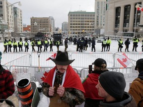 Protestors gather by the police line outside the Chateau Laurier, as police work to restore normality to the capital while trucks and demonstrators continue to occupy the downtown core on Saturday.