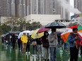 People line up in the rain at a testing site for COVID-19 in Hong Kong, China, Tuesday, Feb. 22, 2022.