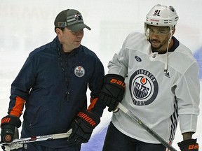 Edmonton Oilers head coach Jay Woodcroft (left) skates with newest Oilers player Evander Kane during team practice in Edmonton on Friday, Feb. 18, 2022.