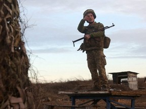 A serviceman of the Ukrainian Military Forces watches on position on the front line with Russia-backed separatists not far from Novognativka village, Donetsk region, Saturday, Feb. 19, 2022.