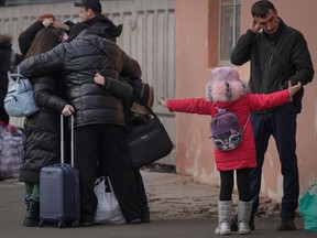People hug while waiting for a Kiev bound train in Kostiantynivka, the Donetsk region, eastern Ukraine, Thursday, Feb. 24, 2022.
