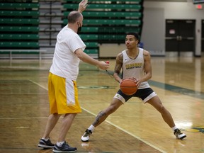 Head coach Barnaby Craddock and guard Tyus Jefferson take part in a University of Alberta Golden Bears practice at the Saville Community Sports Centre in Edmonton on Feb. 24, 2022.