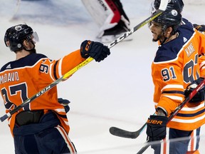 The Edmonton Oilers forward Evander Kane (91) celebrates his third period goal against the New Jersey Devils with Connor McDavid (97) and Zach Hyman (18) at Rogers Place in Edmonton on Saturday March 19, 2022.