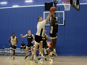 Cole Knudsen, left, and Abdullah Shittu battle for a rebound during a University of Alberta Golden Bears practice at the Saville Community Sports Centre in Edmonton on Thursday, March 31, 2022.