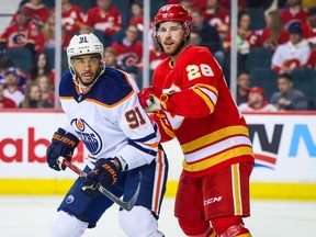 Edmonton Oilers forward Evander Kane (91) and Calgary Flames center Elias Lindholm (28) fight for position during the second period at Scotiabank Saddledome on March 7, 2022.