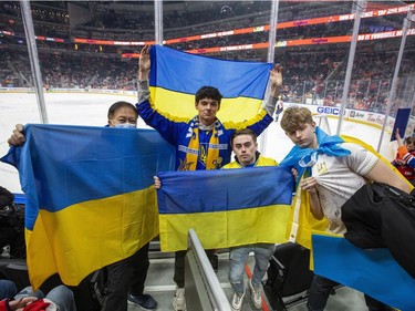 Paul Chan,   Lukian Podilsky, Andrew Krys and Rostyslav Leha hold a Ukrainian flags in support of the Ukrainian people before the Edmonton Oilers play the Washington Capitals on Wednesday, March 9, 2022 in Edmonton.