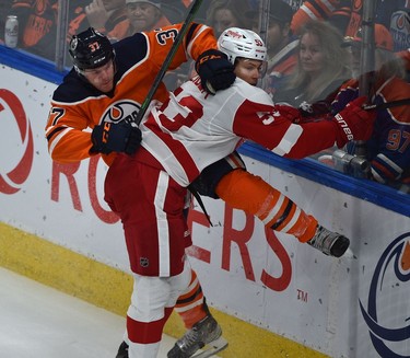 Edmonton Oilers Warren Foegele (37) and Detroit Red Wings Moritz Seider (53) crash into the boards during NHL action at Rogers Place in Edmonton, March 15, 2022.
