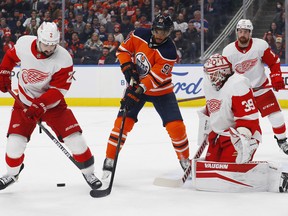Edmonton Oilers forward Evander Kane (91) battles for a loose puck against Detroit Red Wings defenceman Nick Leddy (2) in front of goaltender Alex Nedeljkovic (39) at Rogers Place on Tuesday, March 15, 2022.