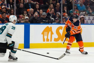 Edmonton Oilers' Ryan Nugent-Hopkins (93) shoots past San Jose Sharks' Logan Couture (39) during first period NHL action at Rogers Place in Edmonton, on Thursday, March 24, 2022.