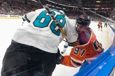 Edmonton Oilers' Connor McDavid (97) battles San Jose Sharks' Brent Burns (88) during first period NHL action at Rogers Place in Edmonton, on Thursday, March 24, 2022.