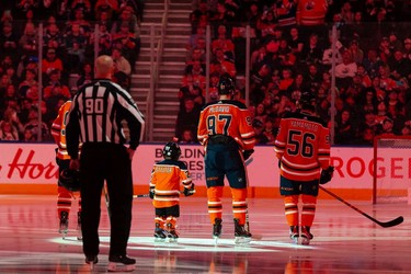 Five-year-old Scotiabank Skater Ben Stelter stands with the Edmonton Oilers and the San Jose Sharks during the national anthems at a NHL game at Rogers Place in Edmonton, on Thursday, March 24, 2022. Ben is currently battling glioblastoma.