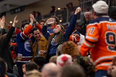 A fan chugs a beer as the Edmonton Oilers take the lead against the San Jose Sharks during third period NHL action at Rogers Place in Edmonton, on Thursday, March 24, 2022.