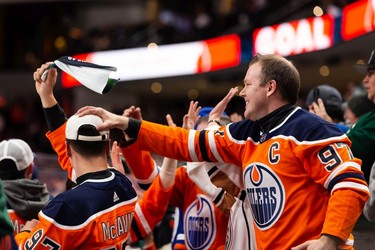 Fans celebrate Edmonton Oilers' Leon Draisaitl's goal on San Jose Sharks' goaltender Kaapo Kahkonen during third period NHL action at Rogers Place in Edmonton, on Thursday, March 24, 2022.