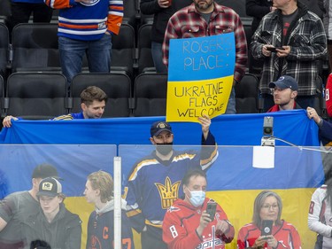 Fans hold a Ukrainian flag in support of the Ukrainian people before the Edmonton Oilers play the Washington Capitals on Wednesday, March 9, 2022 in Edmonton.