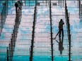 Workers clean an area for arriving passengers before they board buses to their quarantine hotels amid the COVID-19 pandemic, at Hong Kong International Airport, Monday, March 21, 2022.