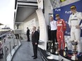 Russian President Vladimir Putin stands on the podium as he congratulates winner and Mercedes Formula One driver Valtteri Bottas, right, of Finland and second-placed Ferrari Formula One driver Sebastian Vettel, second from right, of Germany.
