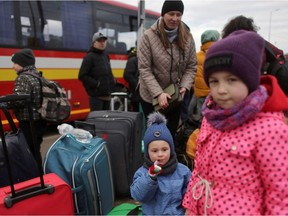 People fleeing the Russian invasion of Ukraine wait for transport after arriving in Slovakia, at a border crossing in Vysne Nemecke, Slovakia, March 5, 2022. REUTERS/Lukasz Glowala REFILE - CORRECTING LOCATION