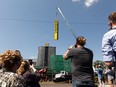 The crowd watches from The Lot across the street as the Roxy Theatre's new sign is installed on 124 Street in Edmonton on July 12, 2021.