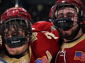 Denver University's Bobby Brink (24) and Carter Savoie (8) celebrate after defeating the University of Michigan, 3-2, in overtime of the NCAA Frozen Four semi-final game at TD Garden on April 07, 2022 in Boston.