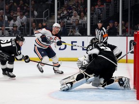 Connor McDavid (No. 97) of the Edmonton Oilers scores in front of Troy Stecher (No. 51) and Jonathan Quick (No. 32) of the Los Angeles Kings, to take a 1-0 lead, during the first period at Crypto.com Arena on April 07, 2022 in Los Angeles, California.