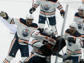 Edmonton Oilers center Connor McDavid (97) celebrates with goaltender Mike Smith and other teammates after scoring the winning goal against the San Jose Sharks during overtime at SAP Center at San Jose on April 5, 2022.