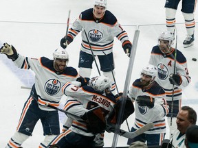 Edmonton Oilers center Connor McDavid (97) celebrates with teamates after scoring the winning goal against the San Jose Sharks during overtime at SAP Center in San Jose on Tuesday, April 5, 2022.