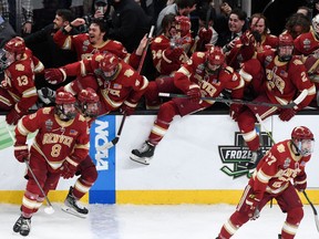 Denver Pioneers forward Carter Savoie (8), defenseman Shai Buium (26), and defenseman Sean Behrens (2) jump over the boards with their teammates at the end of the 2022 Frozen Four college ice hockey national championship game against the Minnesota State Mavericks at the TD Garden on April 8, 2022.