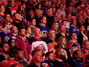 Hockey fans stand for the national anthem as the Edmonton Oilers play the Colorado Avalanche during an NHL game at Rogers Place in Edmonton on April 9, 2022.