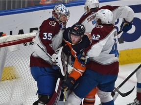 Edmonton Oilers captain Connor McDavid (97) gets sandwiched by the Colorado Avalanche's Josh Manson (42) and goalie Darcy Kuemper (35) at Rogers Place in Edmonton on April 22, 2022.