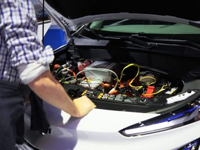 People look at the engine of a Chevrolet Bolt EV at the New York International Auto Show at the Jacob K. Javits Convention Center in New York City, April 15, 2022.