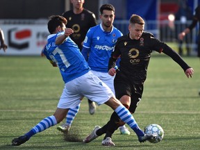 FC Edmonton Hunter Gorskie (27) tries to knock the ball away from Valour FC Moses Dyer (7) during Canadian Premier League soccer action at Clarke Field in Edmonton on Nov. 6, 2021.
