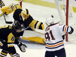 Edmonton Oilers left wing Evander Kane (91) scores a goal against Pittsburgh Penguins goaltender Casey DeSmith (1) as Penguins defenseman Brian Dumoulin (8) defends during the second period at PPG Paints Arena.