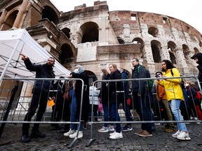 People wait in line before entering the Colosseum as Italy begins to ease some of the COVID-19 restrictions, lifting the obligation to show a health pass to sit at outdoor restaurants, access museums and other activities in Rome, April 1, 2022.