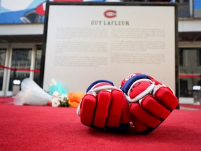Hockey gloves with the No. 10 inscribed on them lay in front of the statue of Montreal Canadiens legend Guy Lafleur, who died at the age of 70, as fans pay their respect outside the Bell Center in Montreal on Friday, April 22, 2022.