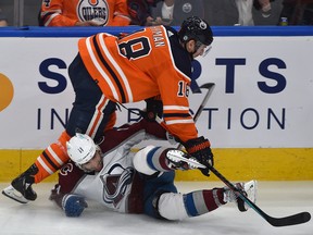 Edmonton Oilers forward Zach Hyman (18) takes down the Colorado Avalanche's Andrew Cogliano (11) at Rogers Place in Edmonton on Friday, April 22, 2022.