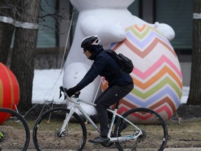 A person rides past a large inflatable rabbit in Winnipeg on Saturday, April 9, 2022.
