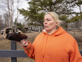 Debbi Wemp holds a burnt slipper that belonged to her mother. The slipper was hung to dry on a clothes line about  30 metres from her home which burnt to the ground on Saturday evening. Debbies Mother and sister-in-law were two of three people that died in the house fire north of Lac Ste. Anne in Darbyson Estates. Taken on Monday, April 25, 2022 near Lac Ste.Anne.